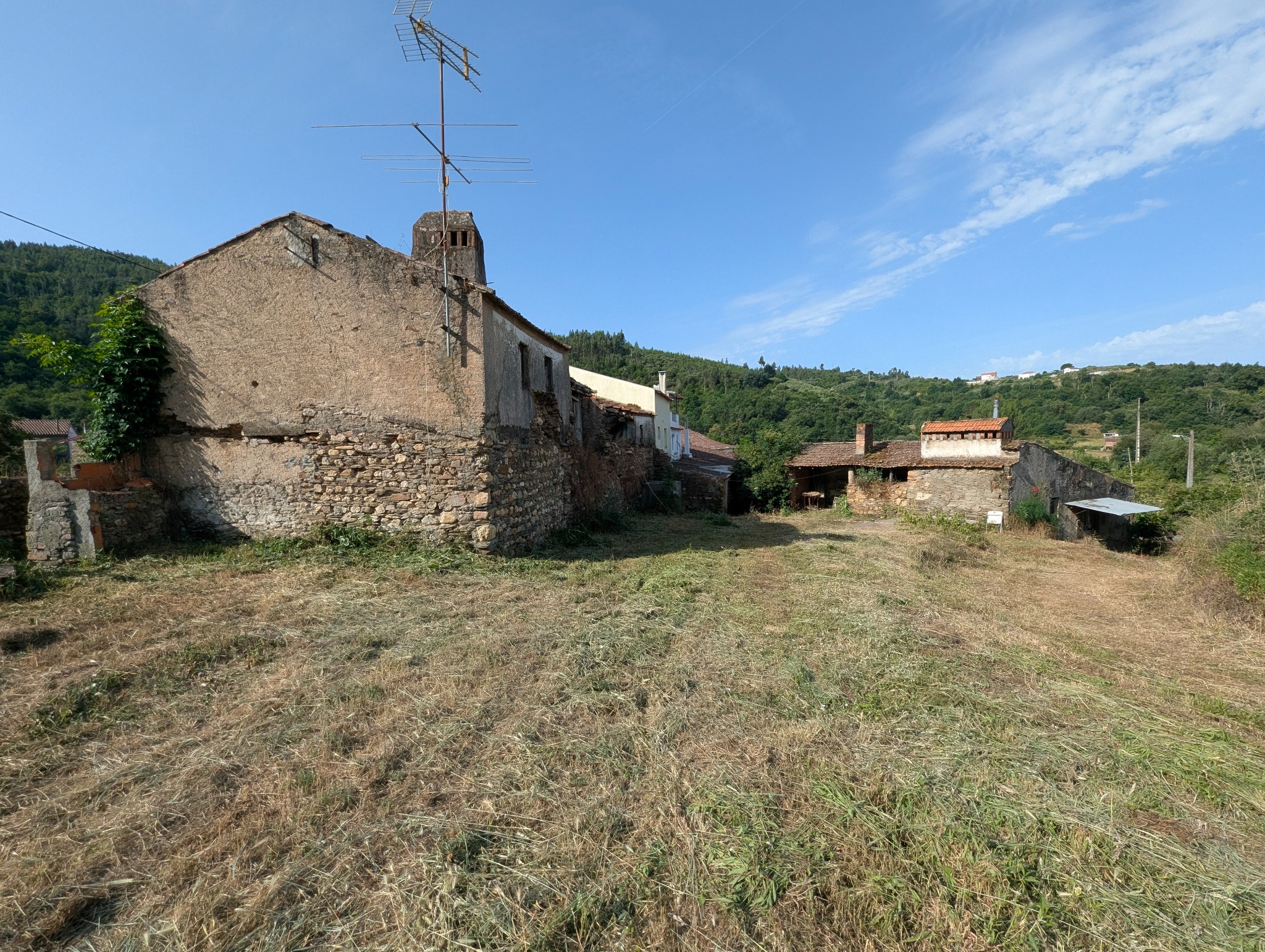 Wide view across the combined logradouro and schist ruins